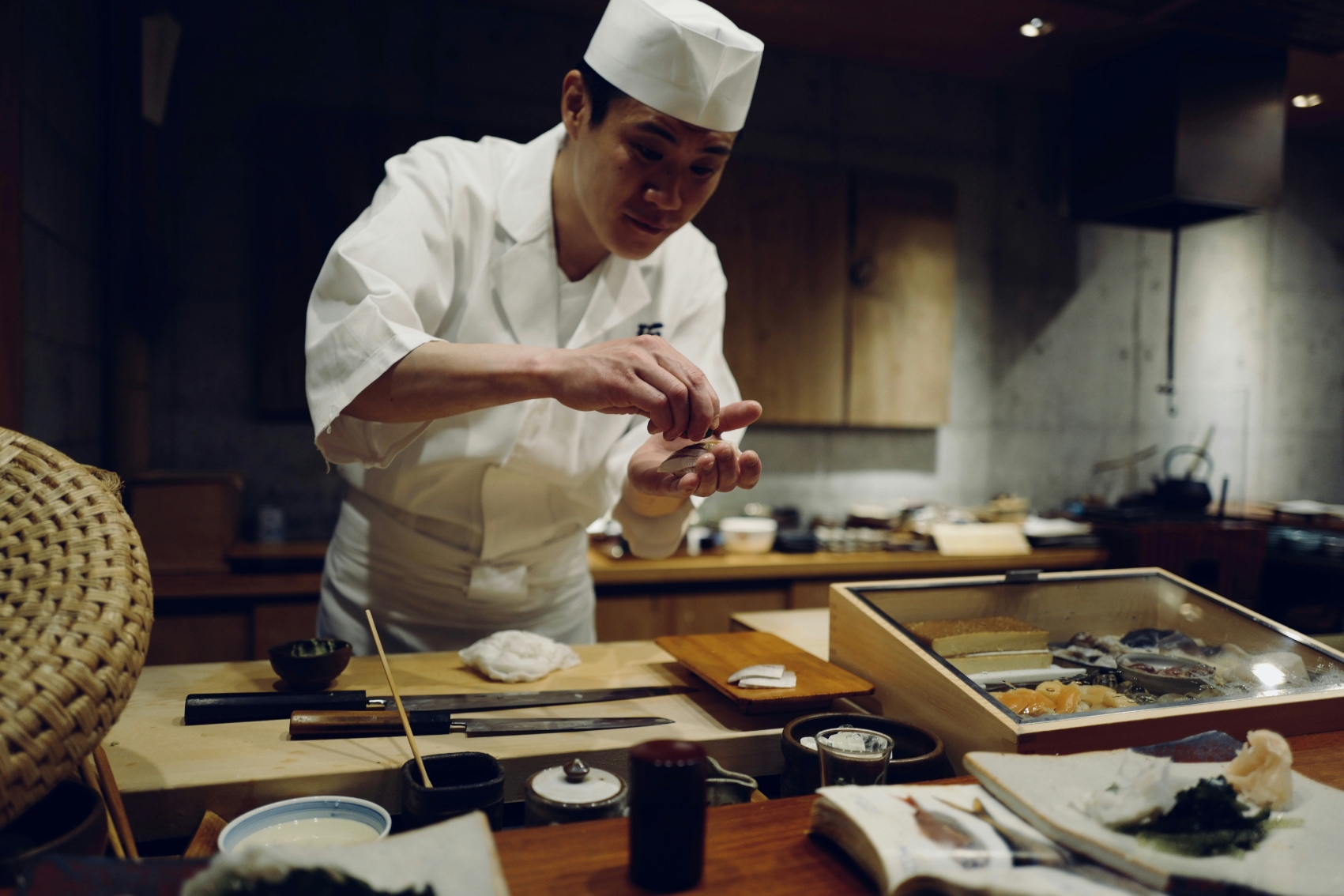 A sushi chef carefully preparing nigiri for a traveller