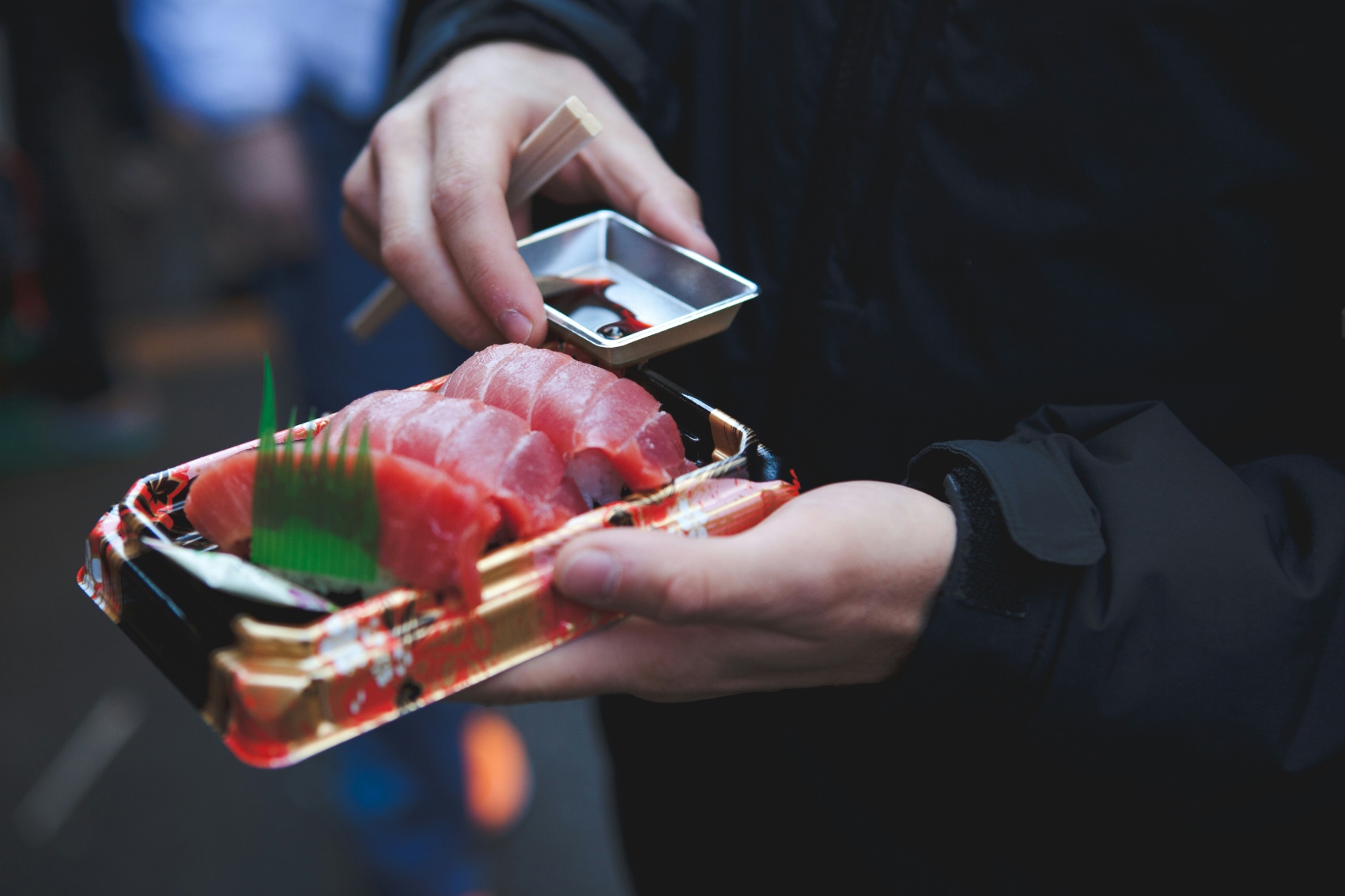 a traveller gets ready to eat fresh sushi takeout from Tsukiji fish market